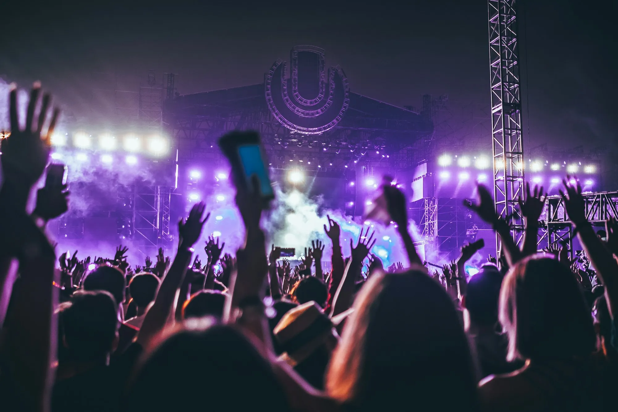 Public mains levées sous des projecteurs violets